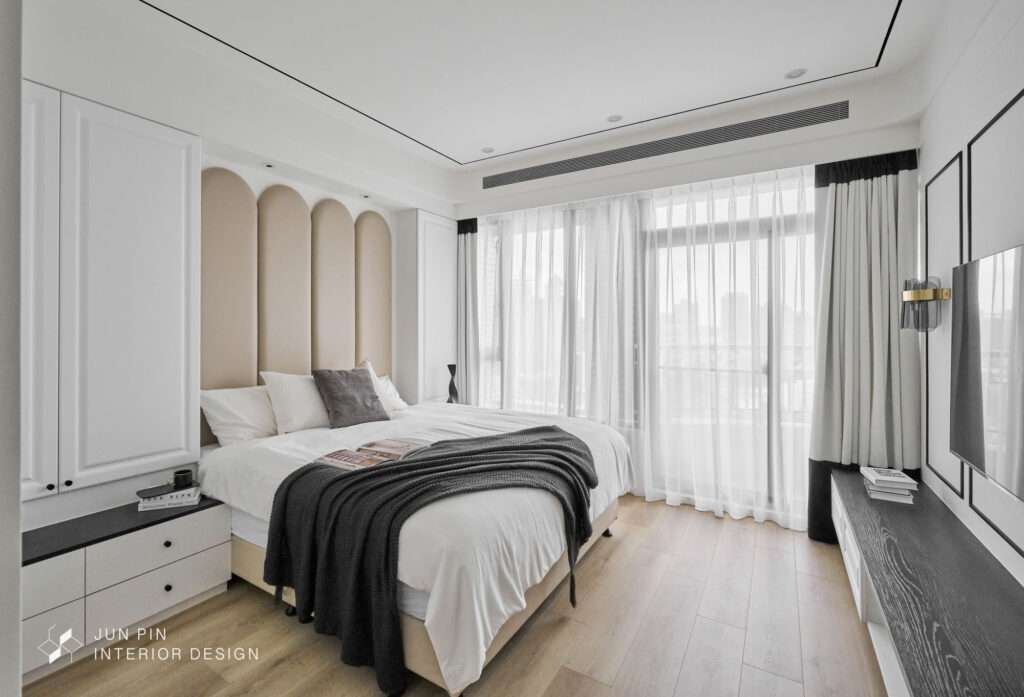 走至主臥室，白色基底搭配黑色線條塑造俐落簡約的風格。選用可可色床頭繃布，藉由其圓弧的線條悄然地呼應拱門的弧線感。