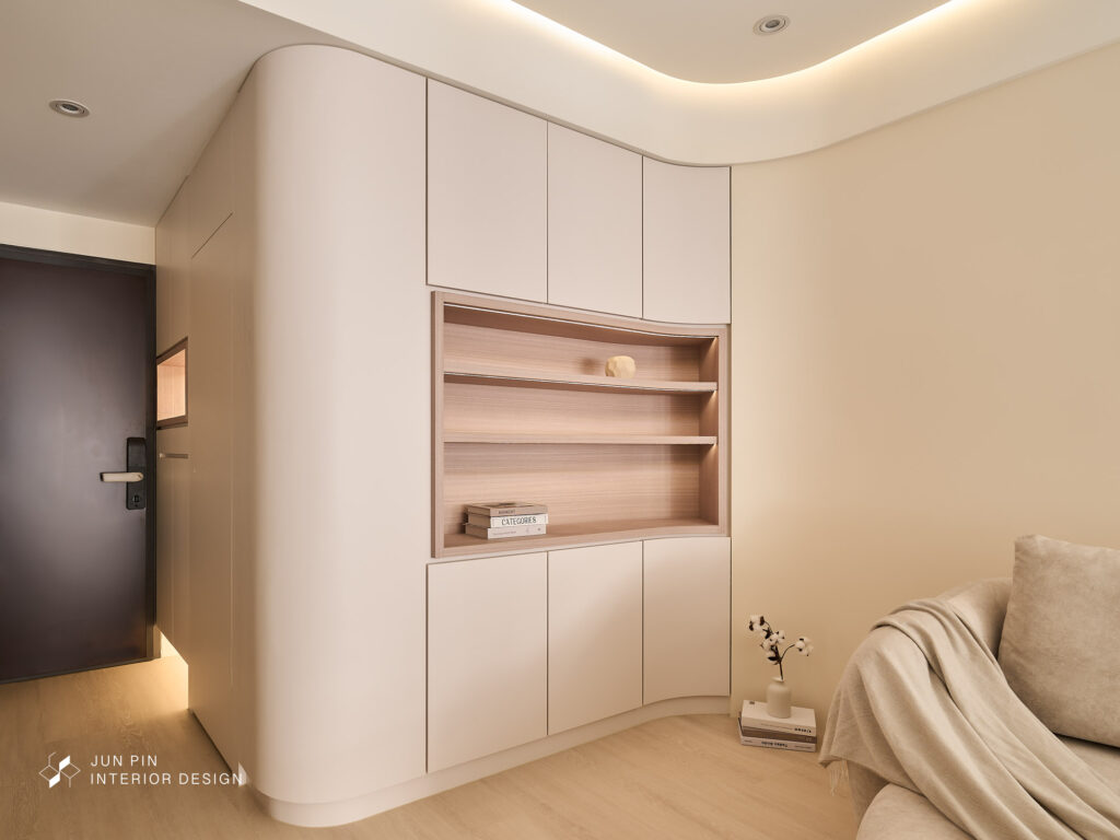 無論是玄關櫃轉角、天花造型，或電視櫃邊緣，皆以圓弧語彙串聯，使視覺更順滑、也增添親和力。