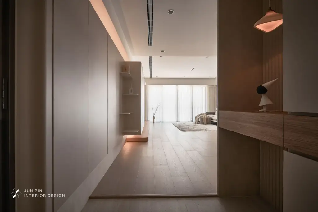 玄關地坪選用洞石地磚， 兼顧耐用與好清潔的實用性。入口端景以弧形格柵作為視覺亮點，柔化線條，也為回家鋪陳出安靜從容的過渡。