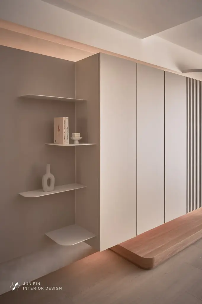 電視牆以溫潤質感材質搭配間接照明，讓牆體量感變得柔和而沉靜。線材與設備全數隱藏，讓視覺回歸純粹。