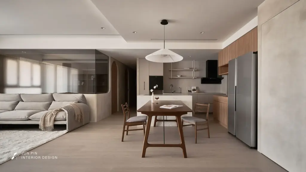 中島吧檯成為料理、用餐與交流的核心，餐櫃整合收納與展示機能，線條簡潔、比例克制。