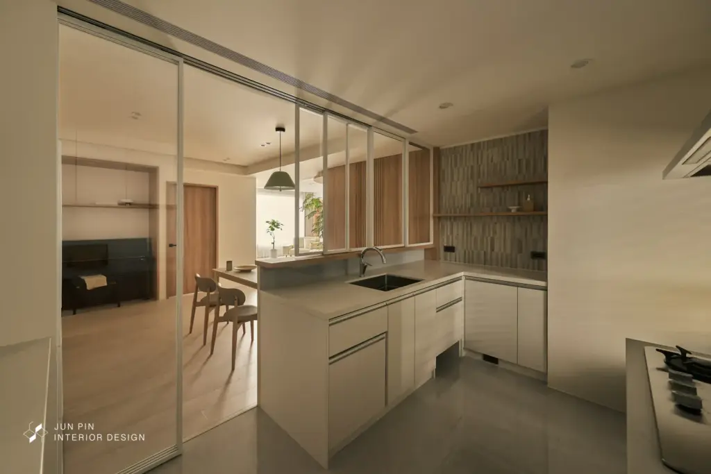 原始格局為封閉式廚房，考量屋主實際使用需求，設計師建議新增中島與備餐檯面，提升料理與收納的實用性，並將廚房調整為半開放式，讓公共空間在視覺與動線上更加流暢。