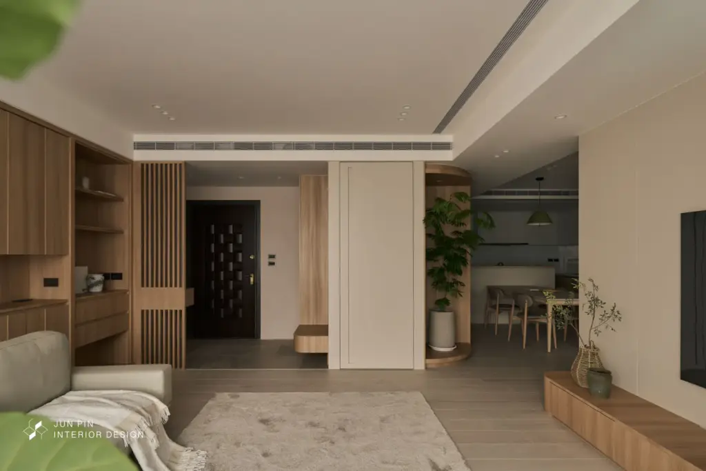 客廳旁設置隱藏門整合儲藏空間，使多功能收納融入立面之中，維持公共空間的整潔與一致性。