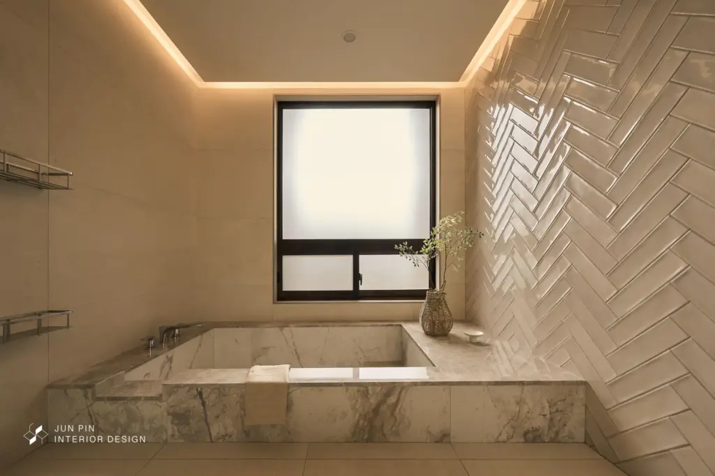 降板式浴缸及面盆檯面皆使用大理石鋪設，壁面運用人字拼的方式，淋浴區及乾區的地磚利用不同地磚來分割