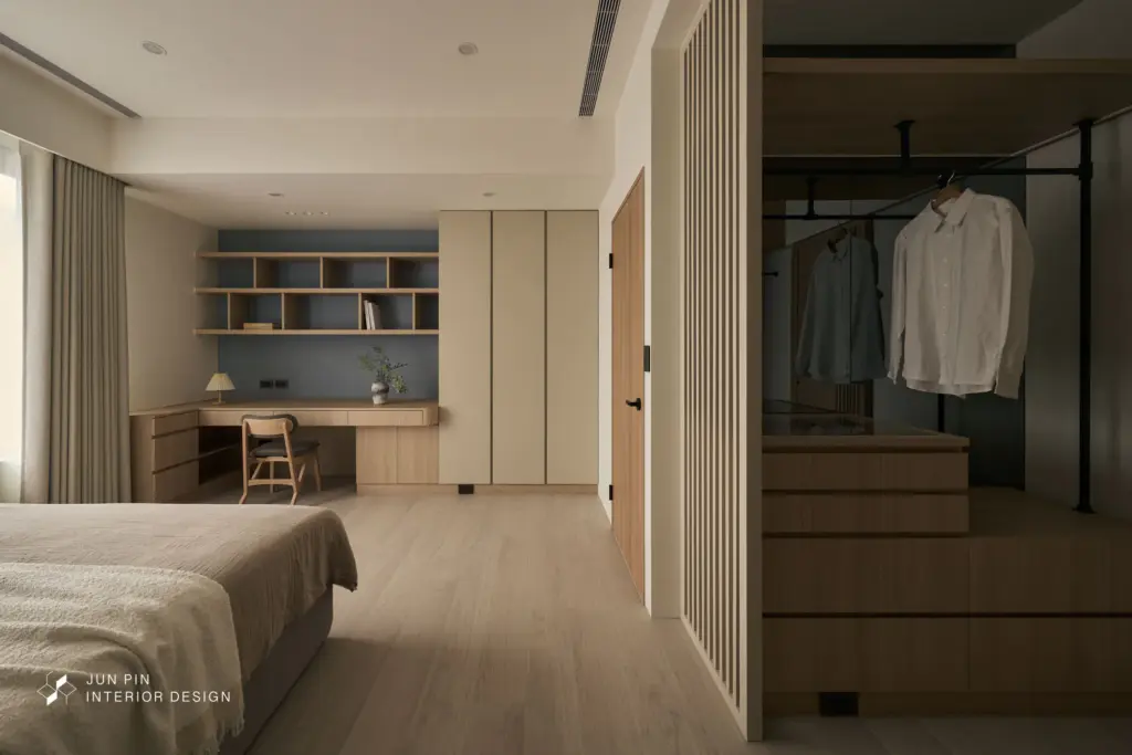 臥室規劃小型更衣室，床頭因結構樑位調整配置，新增床頭矮櫃並強化收納機能，在有限空間中兼顧實用性與視覺平衡。