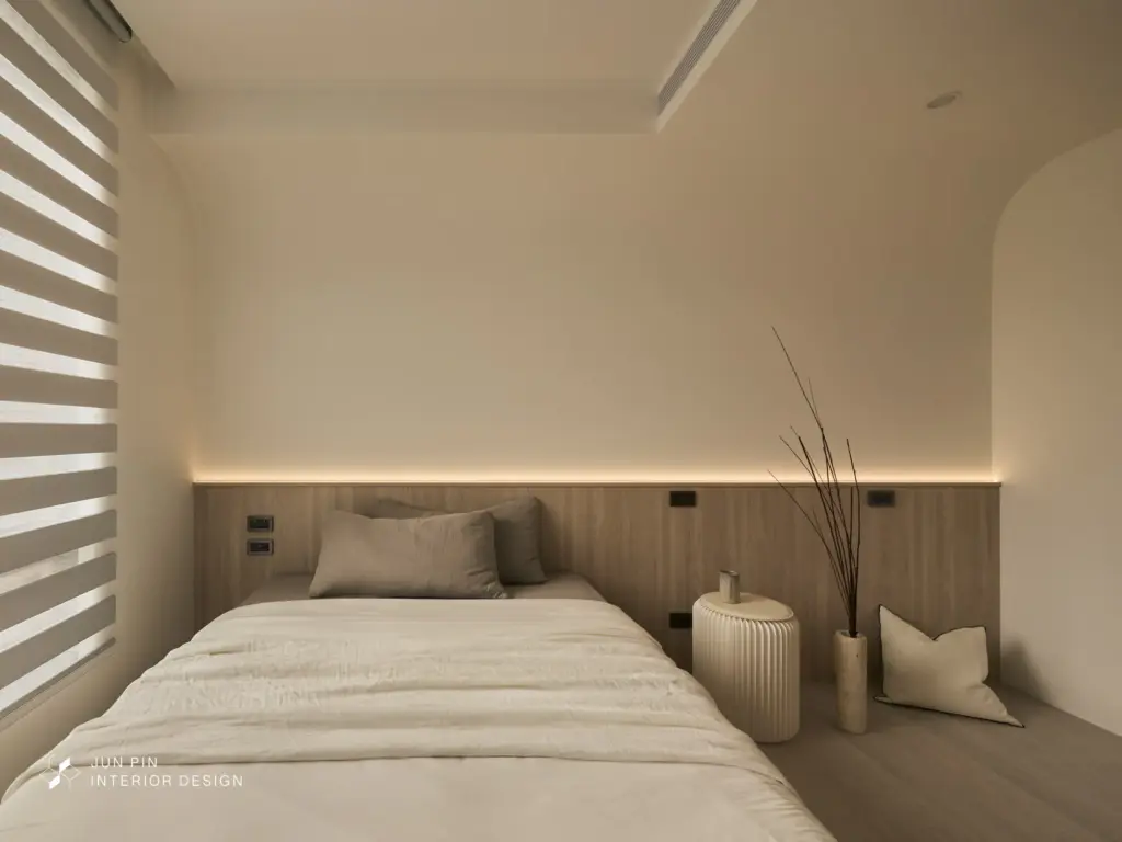 次臥採用木紋床頭搭配間照營造溫馨視覺