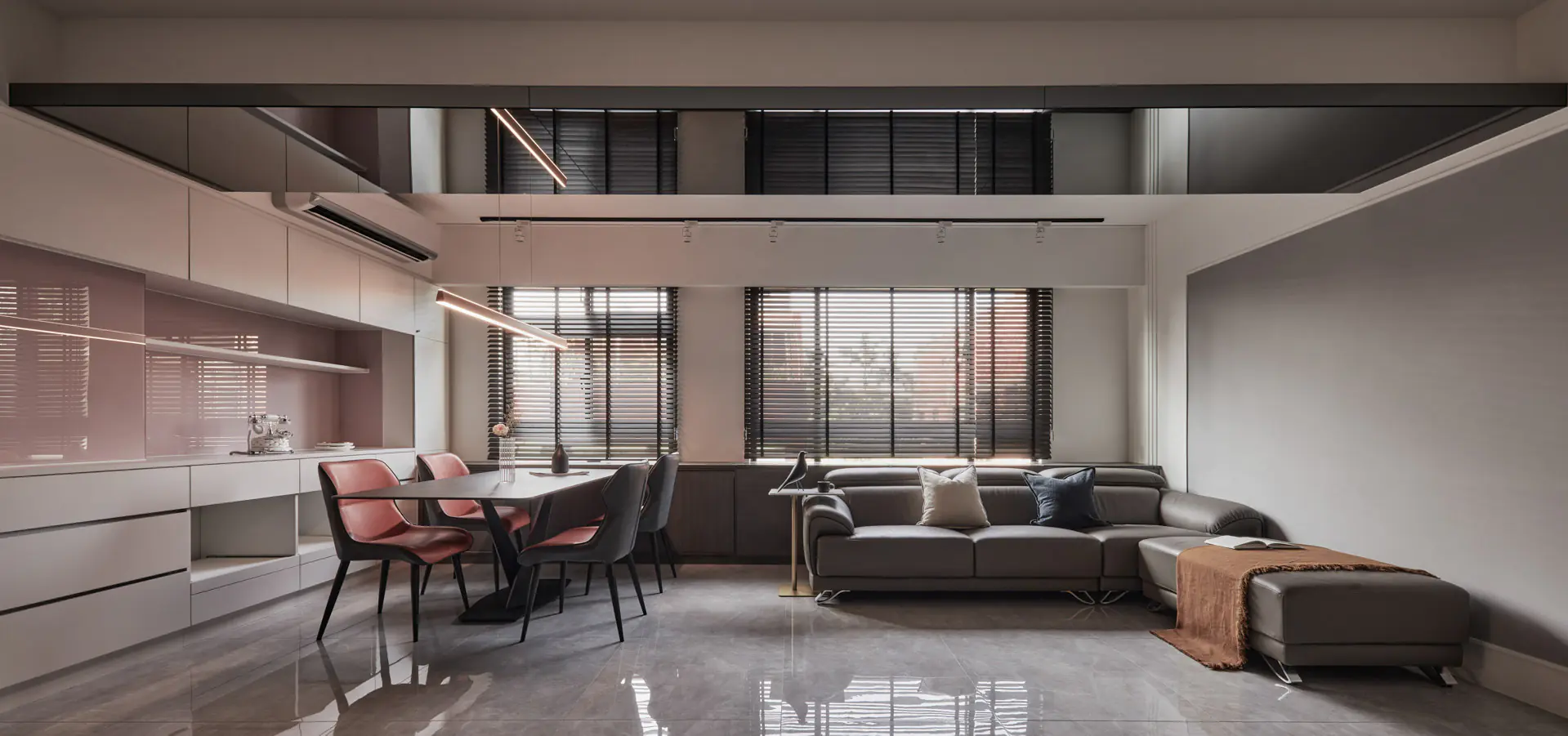 現代輕奢風客廳設計透過天花板灰鏡反射放大空間，結合大板磚地坪與高質感皮沙發展現大器品味。