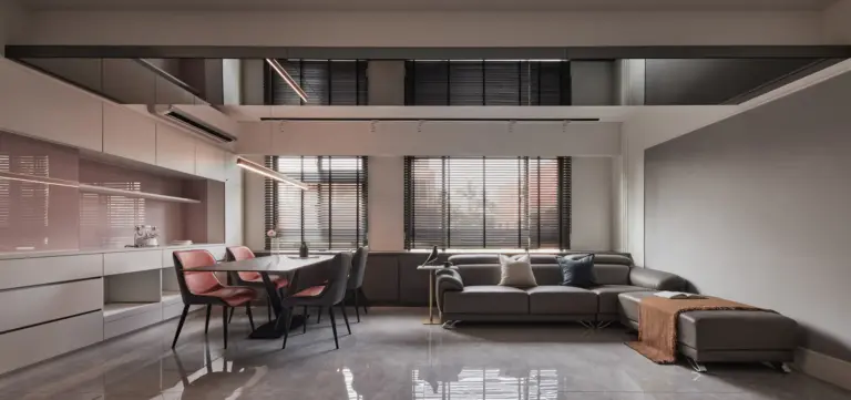 現代輕奢風客廳設計透過天花板灰鏡反射放大空間，結合大板磚地坪與高質感皮沙發展現大器品味。