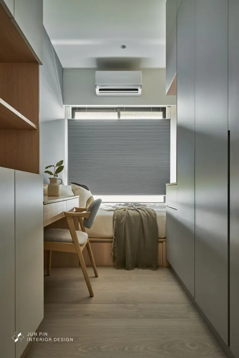 次臥空間較小，靠床邊的地方設置了開放掛衣架，讓床的空間不那麼壓迫，也提供了汙衣櫃的功能。