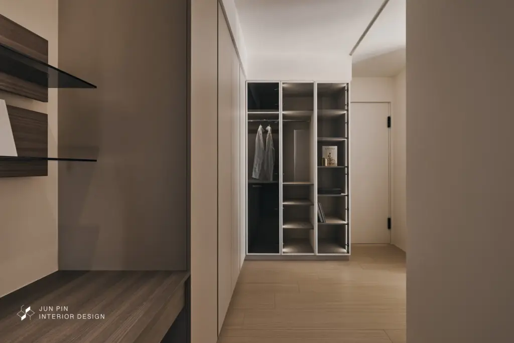 縮減走道空間，主臥房門採隱藏式滿版設計，讓立面視覺更乾淨、不擁擠。 漂浮睡眠區： 寢室牆面延續藝術塗料，床架選用內縮床腳的「漂浮感」設計，床底配置感應式燈條，兼具美感與夜間下床的安全性。