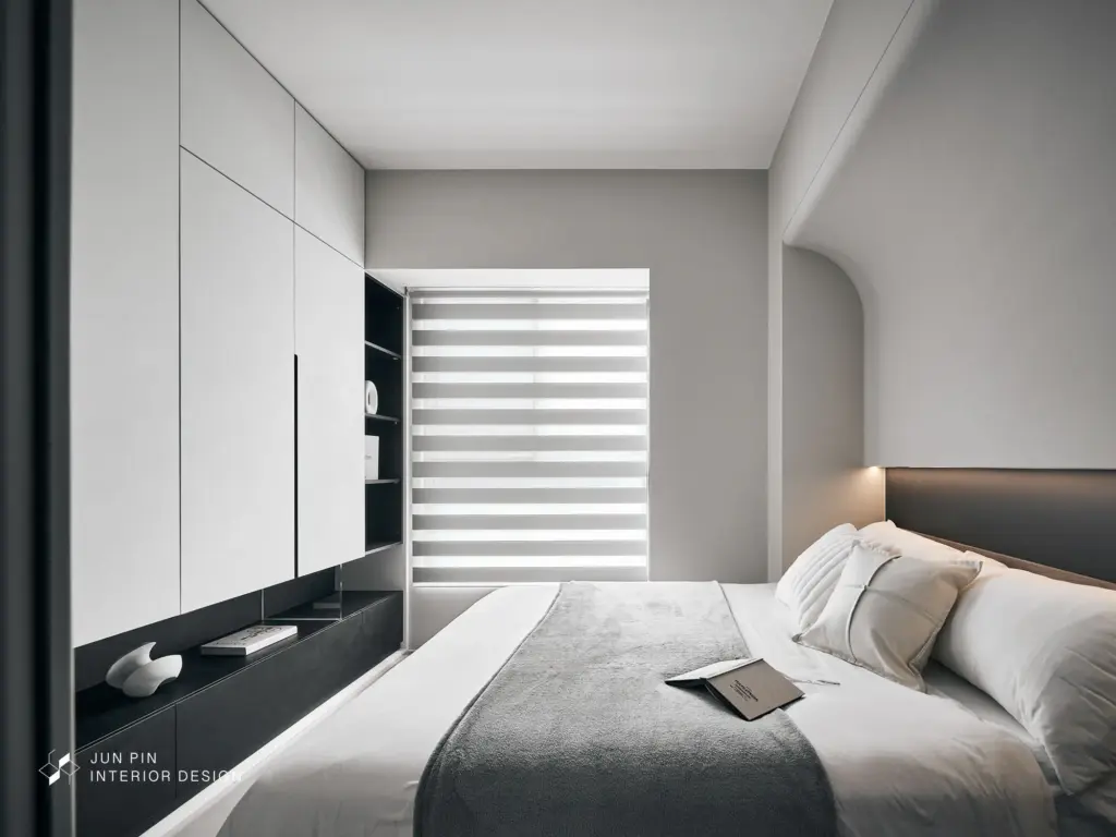 主臥以簡單舒適為核心配置。圓弧造型包覆床頭上方結構梁，柔化線條同時避免梁壓床疑慮。