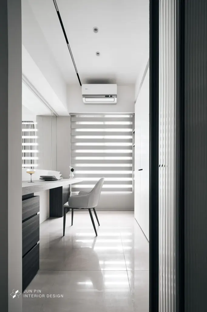 將原本封閉的書房改以全玻璃隔間取代，瞬間瓦解客餐廳的擁擠感，讓光影在斑馬簾的律動下於公領域自由流淌