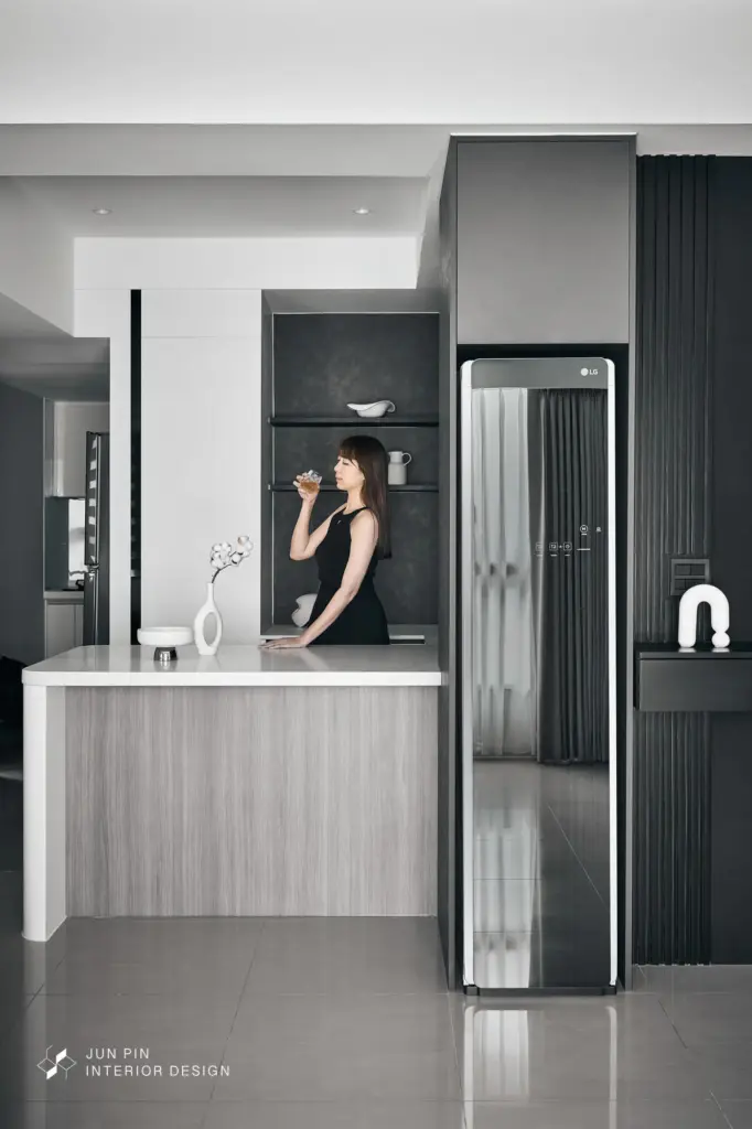 以弧形中島取代傳統餐桌，釋放動線，讓單身生活更具彈性，並透過低飽和色調建立一致的沉穩基調。