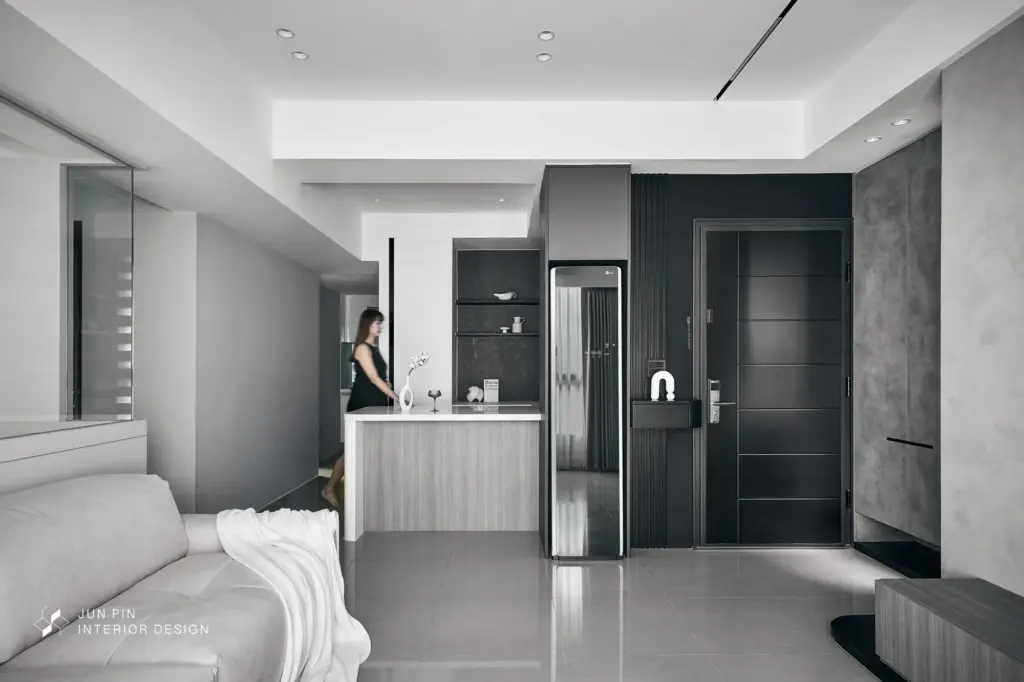 以黑、灰、白、銀等低飽和色調為基調。透過「義大利進口特殊漆」與「黑色鋁件」堆疊出理性的空間深度，並適時加入「灰色木紋」地板與櫃體，平衡冷色調空間的溫度。