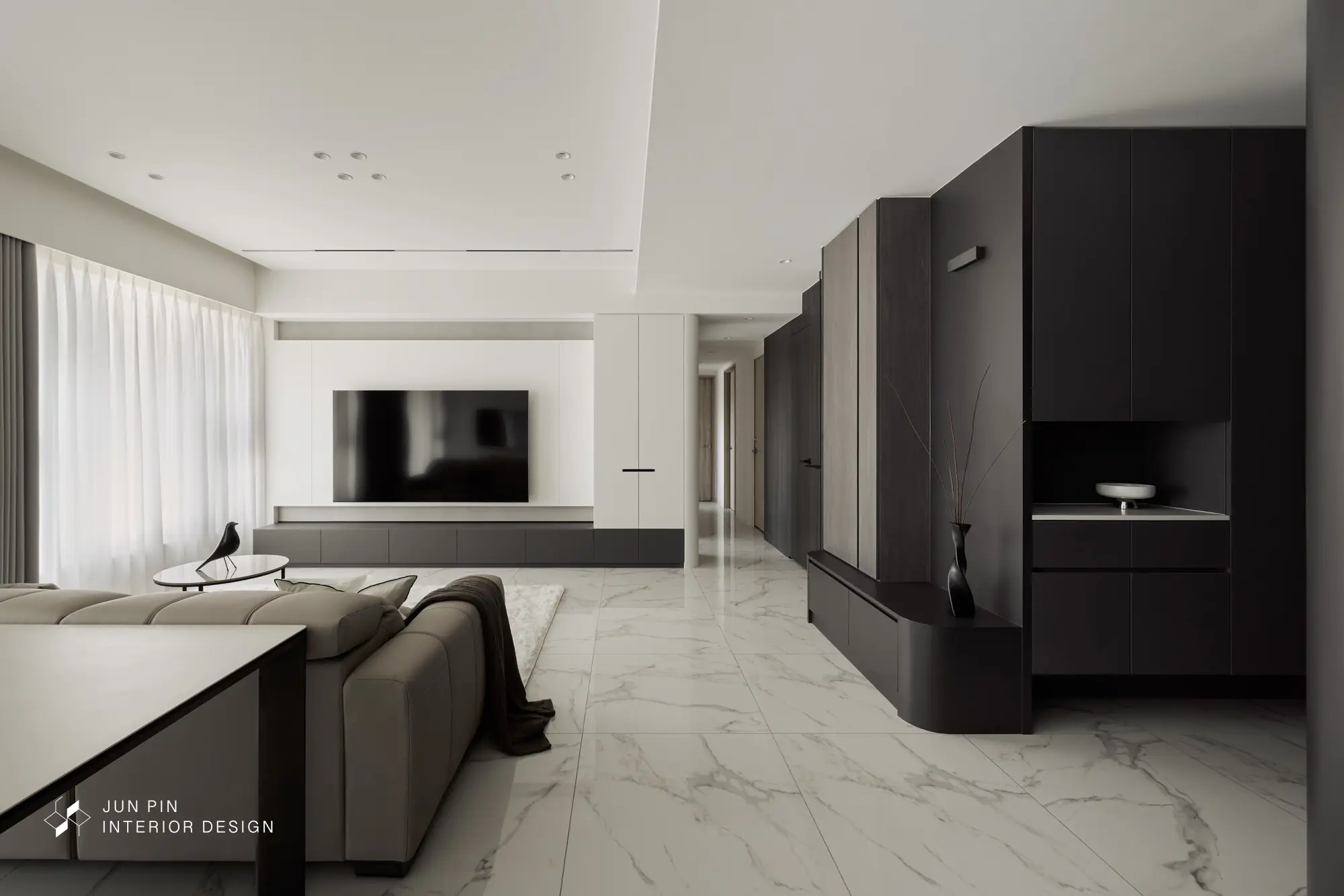 進入客廳，同樣使用建商的石紋地坪，電視牆使用烤漆白色加上特殊漆創造出低調的層次感，而電視牆和電視邊櫃皆使用白色烤漆，讓空間留白，也藉此展現空間乾淨、簡單的視覺效果。