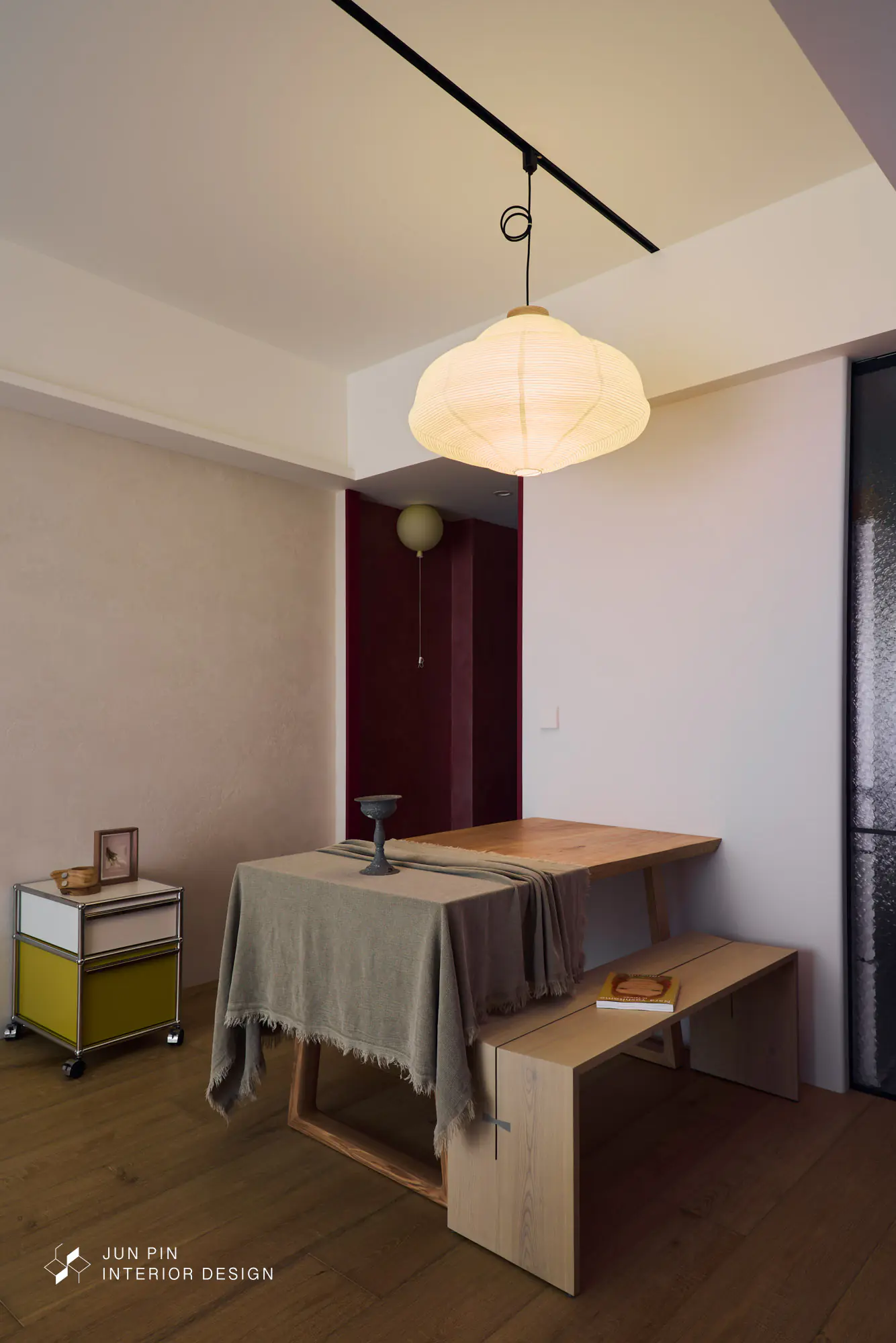 郡品室內設計－林口立軒天翠21坪新成屋餐廳，日式燈籠造型吊燈近景，原木餐桌搭配麻灰桌旗與鐵燭台，USM推車側邊，背景酒紅色門洞與氣球壁燈，長虹玻璃拉門